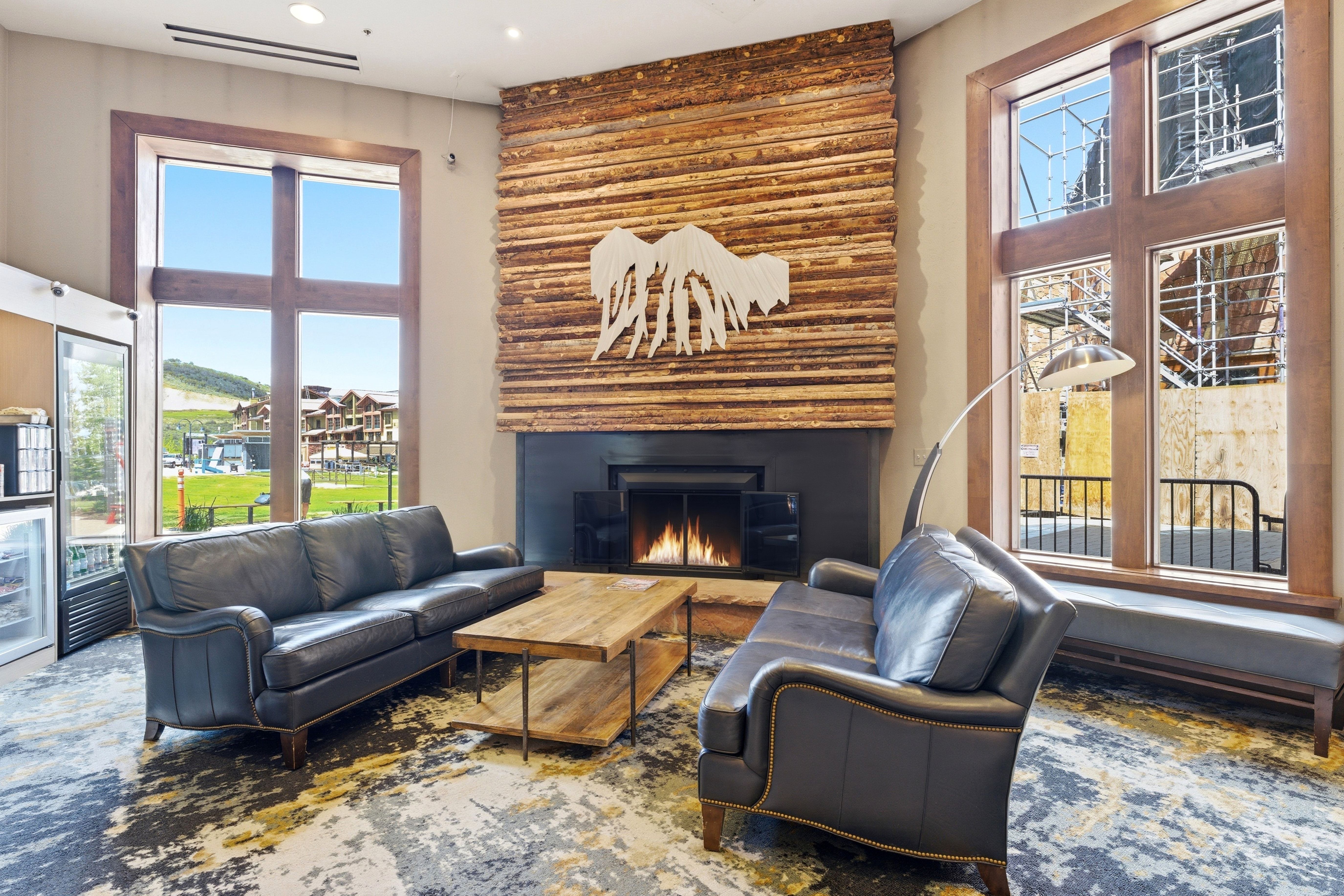 Expansive living area featuring a fireplace with a wood-plank accent wall and a dark mantel