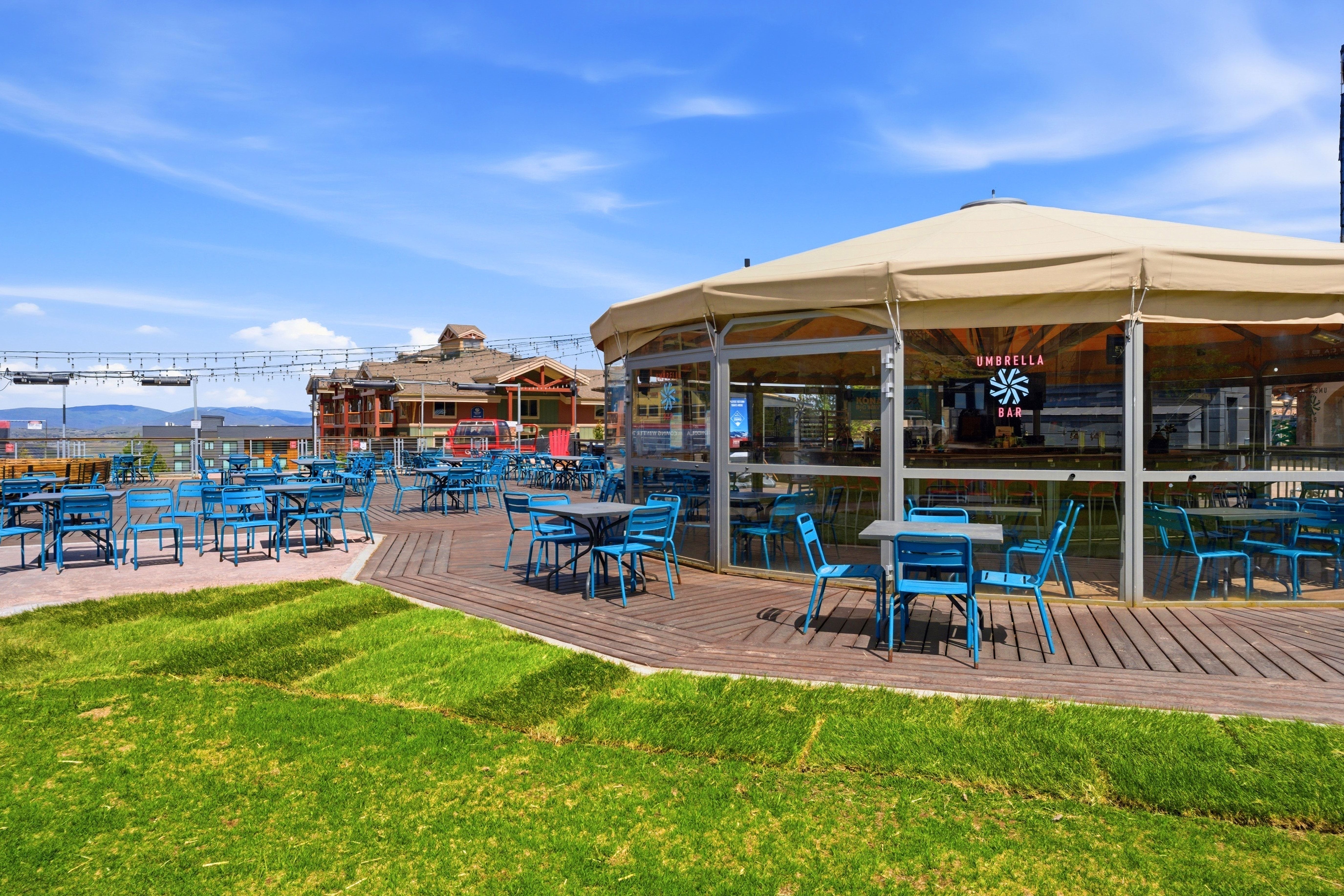 Outdoor dining area featuring a circular tent structure with clear paneling and a light-colored canopy
