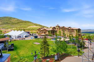 Expansive green space featuring mature trees and mountain scenery