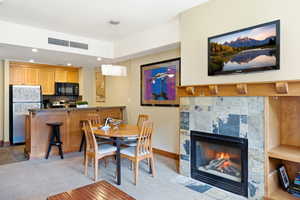 Living area featuring a fireplace with stone tile surround, an integrated media niche, and a natural wood mantel