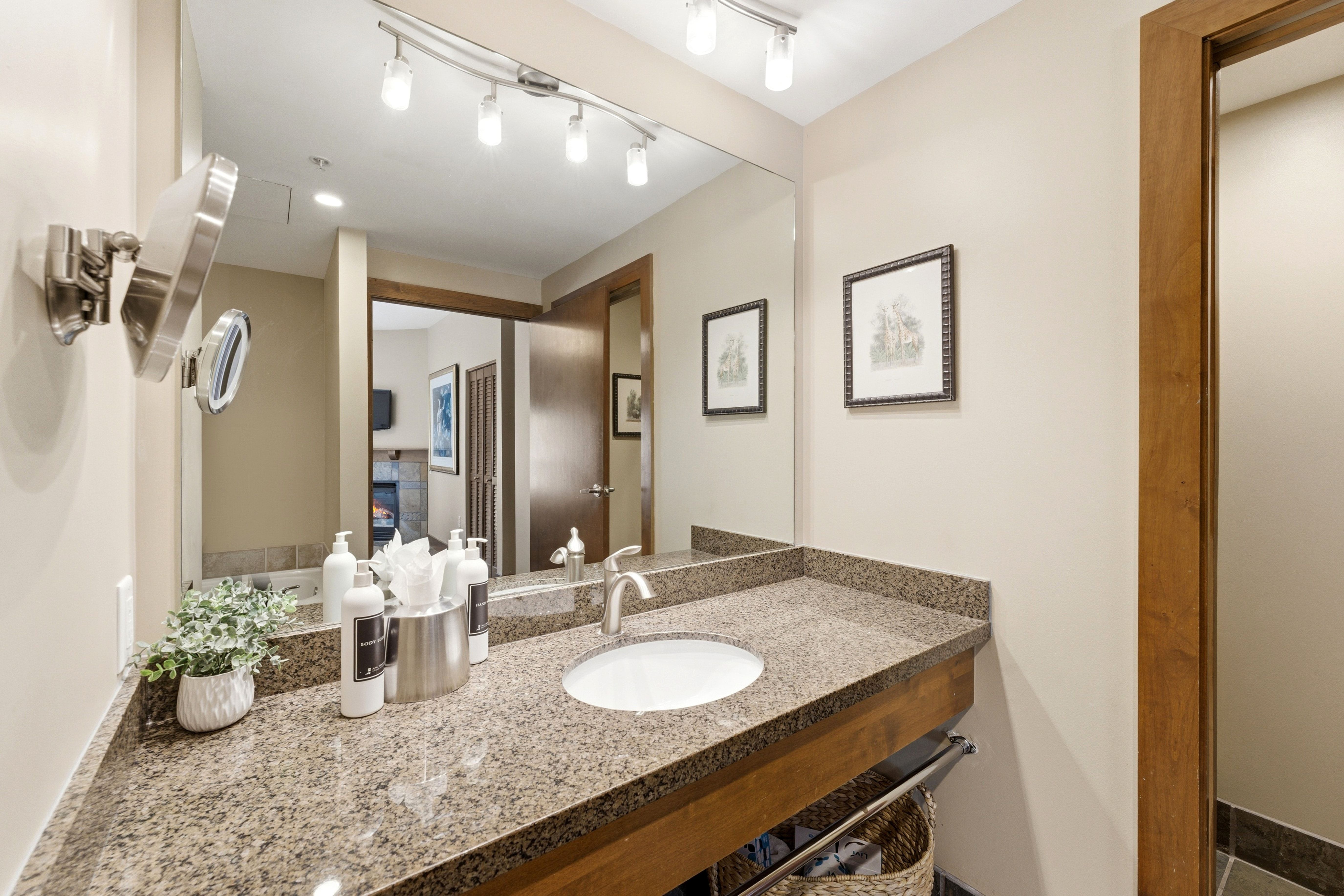 Vanity with a granite countertop, undermount sink, and brushed nickel faucet