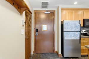 Entryway with slate tile flooring and a louvered bifold door closet