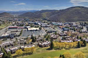 Expansive aerial capturing a vibrant community nestled among foothills with mountain backdrops