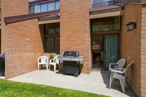 Exterior patio featuring a concrete surface, brick facade, and a sliding glass door entry