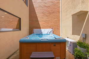 Outdoor spa featuring a wood-finish cabinet and a blue-toned interior