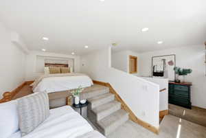 Multi-level room with recessed lighting, platform sleeping area, and wood-finish trim