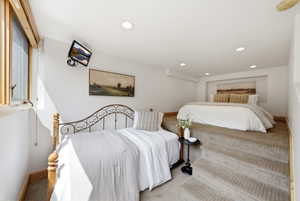 Carpeted split-level room featuring recessed lighting, a raised platform, and a built-in bed nook