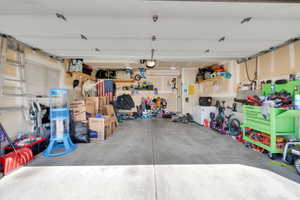 Garage with concrete flooring, overhead lighting, and a side window