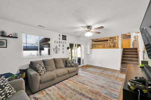 Spacious living area featuring wood-finish flooring and a ceiling fan