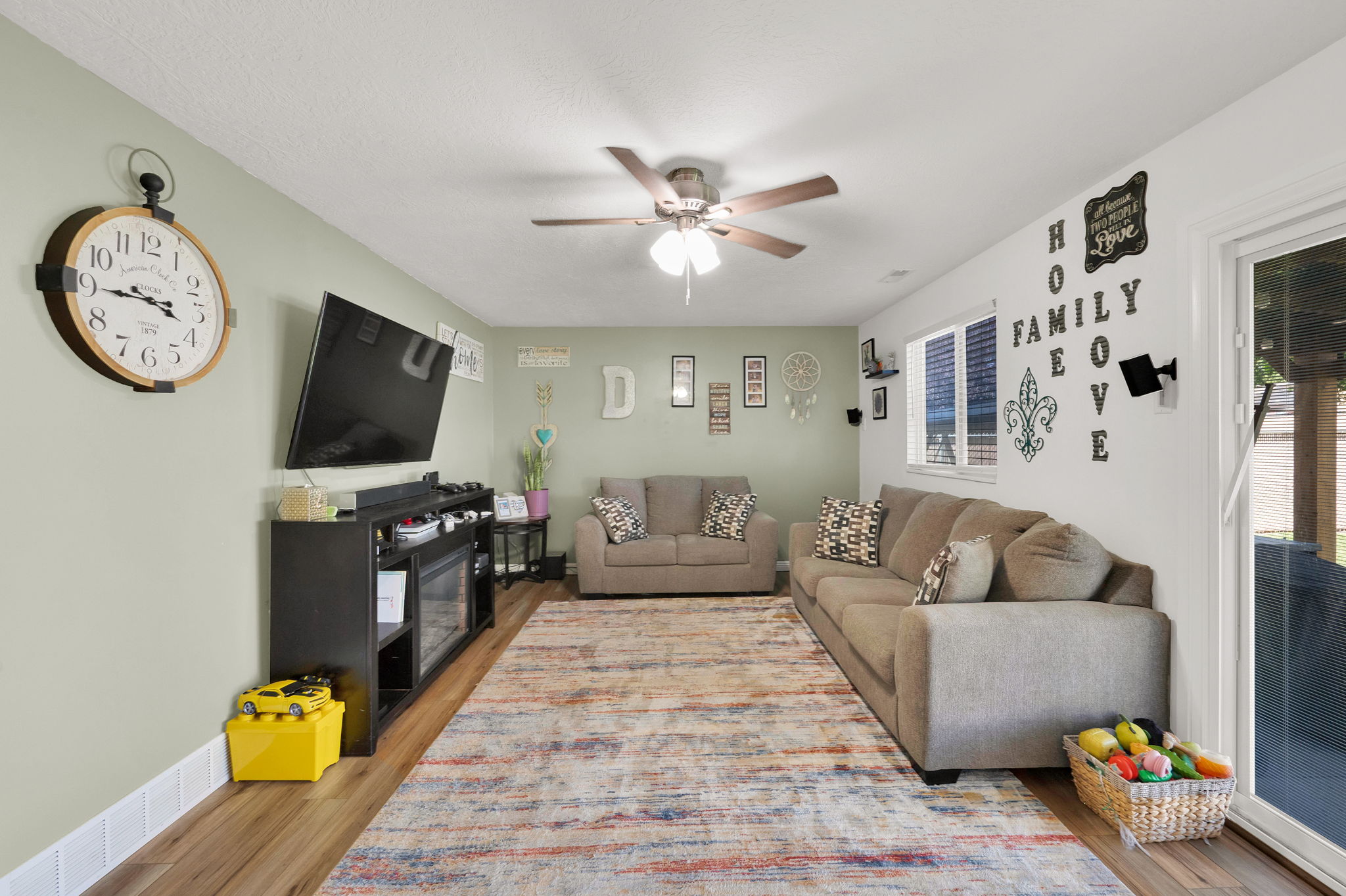 Open-concept living space featuring wood-finish flooring and a ceiling fan