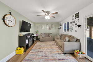 Open-concept living space featuring wood-finish flooring and a ceiling fan