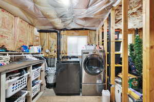 Unfinished basement area featuring exposed wood framing, ceiling insulation, and a utility sink