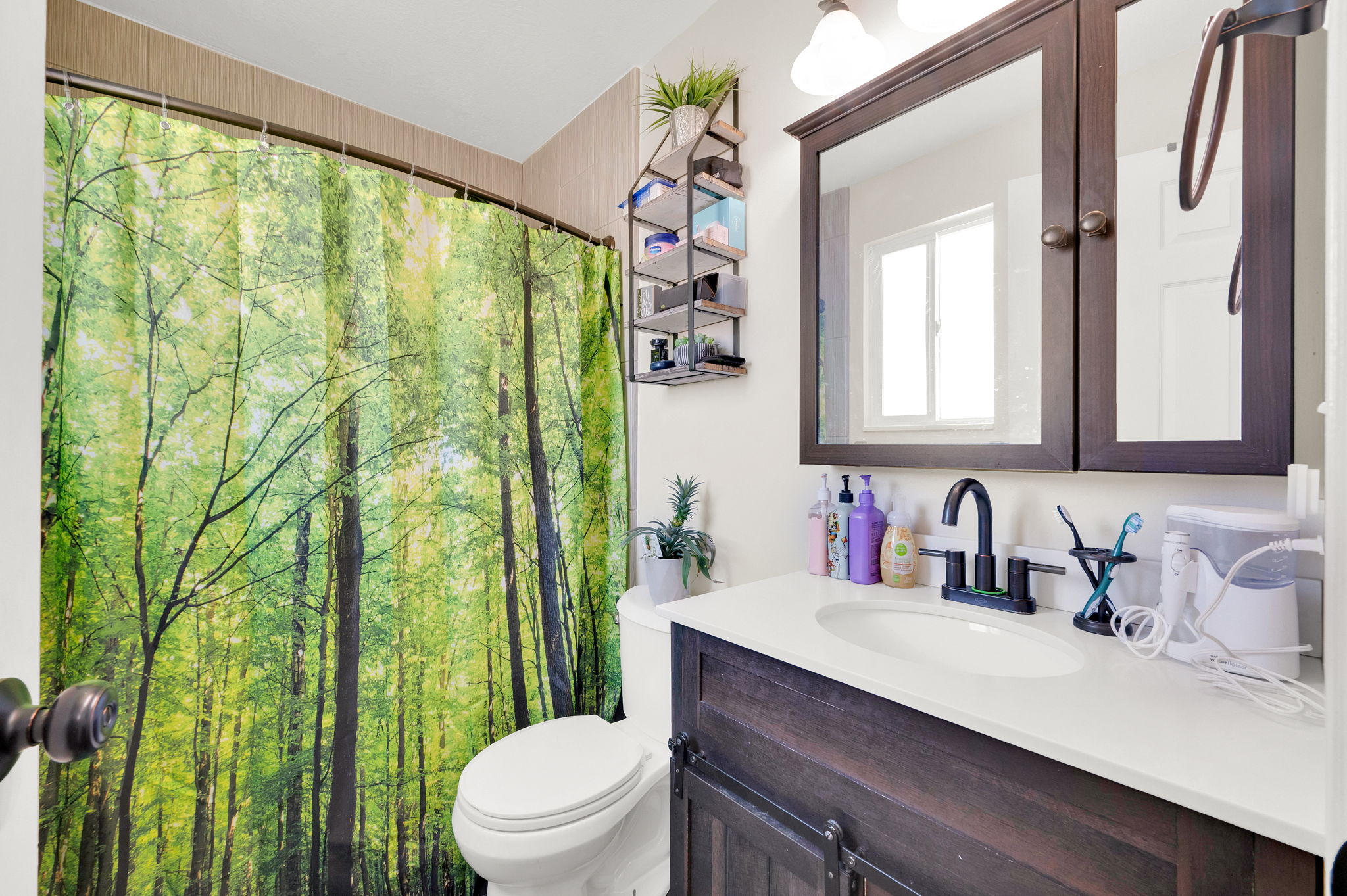 Bathroom featuring a dark wood-finish vanity with a white countertop and oval under-mount sink