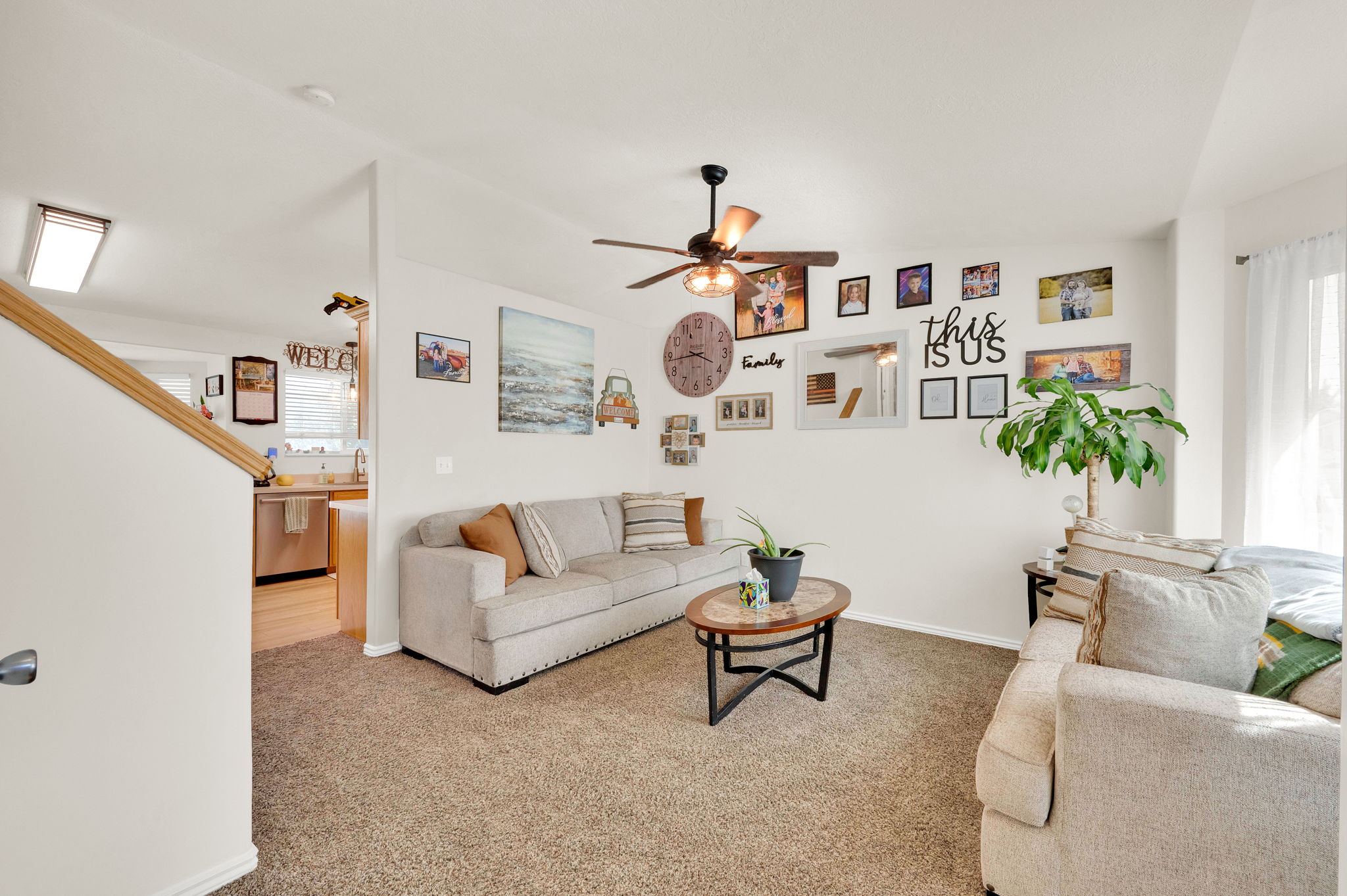 Open concept living space featuring carpeted flooring and a ceiling fan with integrated lighting