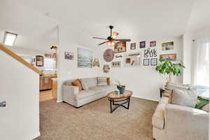 Open concept living space featuring carpeted flooring and a ceiling fan with integrated lighting