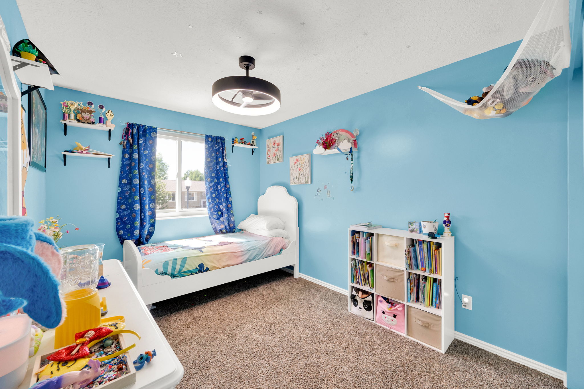 Recessed window with white trim, light blue walls, and textured carpet flooring