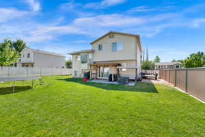 Expansive rear yard featuring a verdant lawn, a concrete patio, and a wood pergola