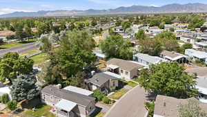 Community aerial showcasing residential units with pitched roofs and surrounding mature trees