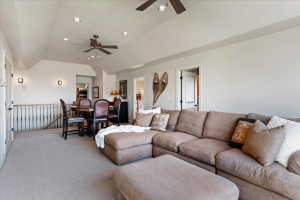 Spacious upper-level room featuring vaulted ceilings, recessed lighting, and light-colored carpeting