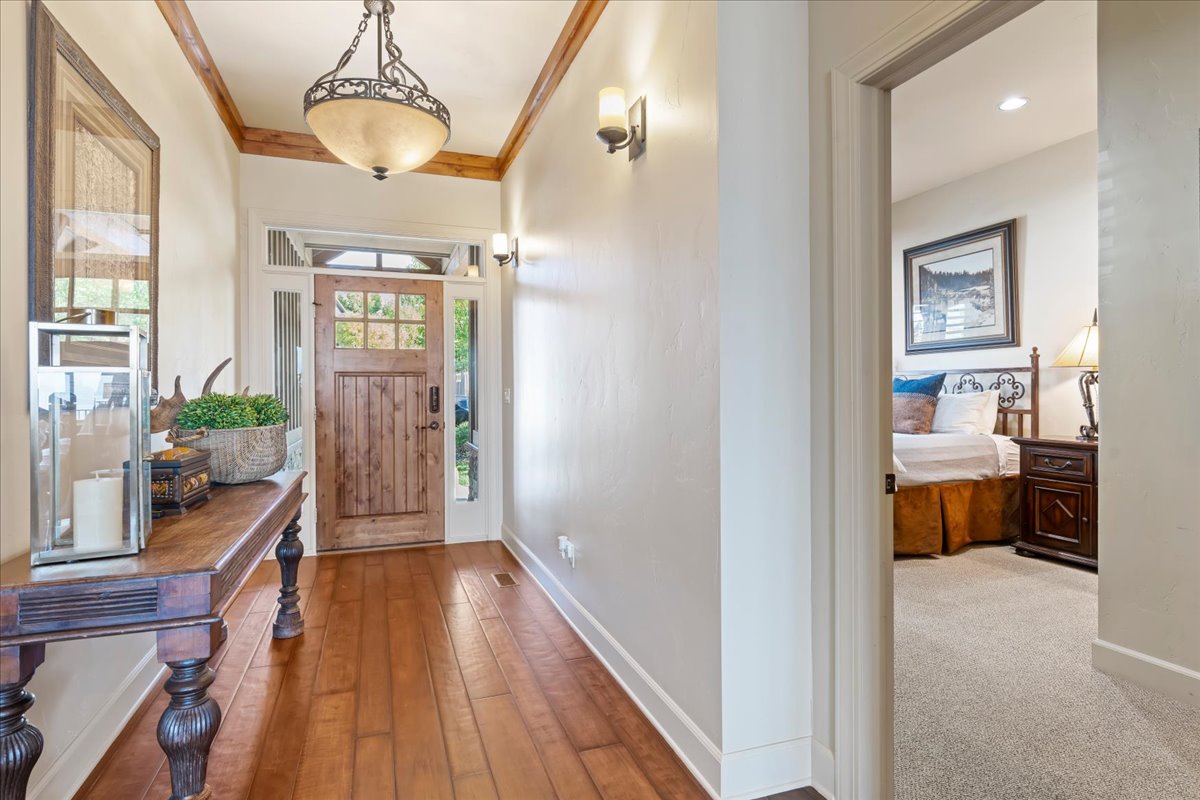 Entryway featuring wood-finish flooring, a wood front door with glass panels, and decorative transom and sidelights