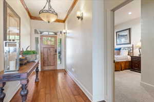 Entryway featuring wood-finish flooring, a wood front door with glass panels, and decorative transom and sidelights