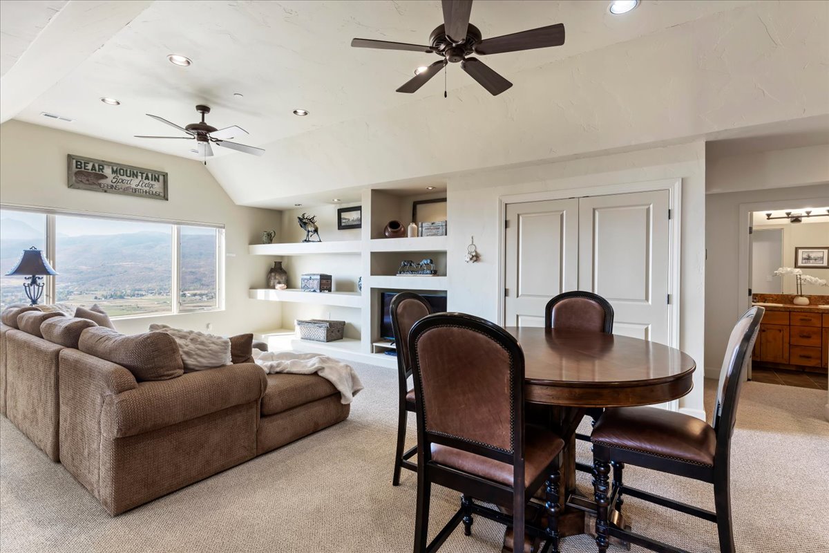 Open-concept living space with vaulted ceilings, recessed lighting, and dual ceiling fans