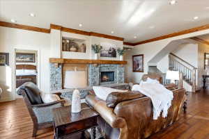 Living area featuring a stone fireplace with a wood mantle, wood-finish flooring, and recessed lighting