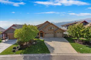 Contemporary exterior featuring multiple roof peaks, a two-car garage, an additional single-car garage, and a covered entry