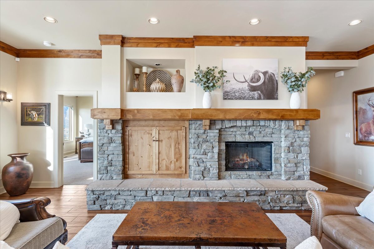 Stone-clad fireplace featuring a wood mantel and hearth