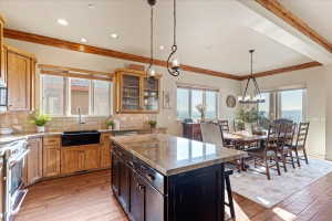 Kitchen and dining area featuring wood-finish flooring, exposed ceiling beams, and recessed lighting