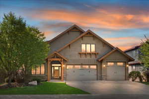Craftsman-style exterior featuring a multi-gable roofline, board and batten siding, and stone accents