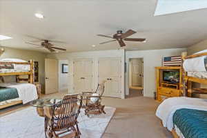 Carpeted room featuring recessed lighting, two ceiling fans, and two sets of double-door closets
