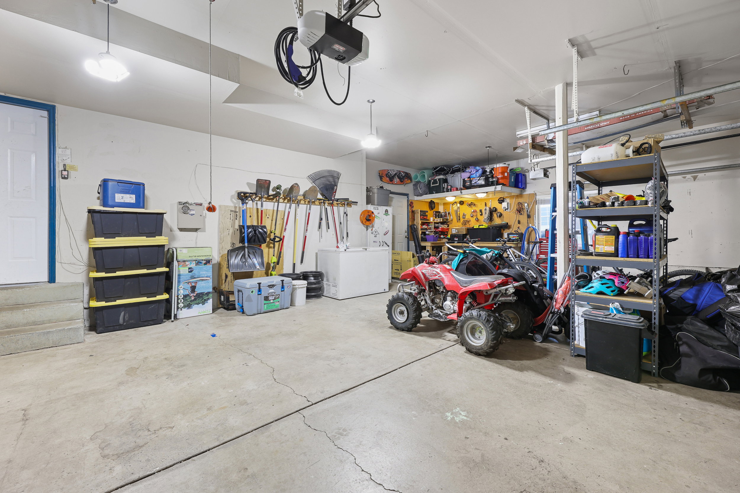 Spacious garage featuring a concrete floor, white walls, and overhead lighting