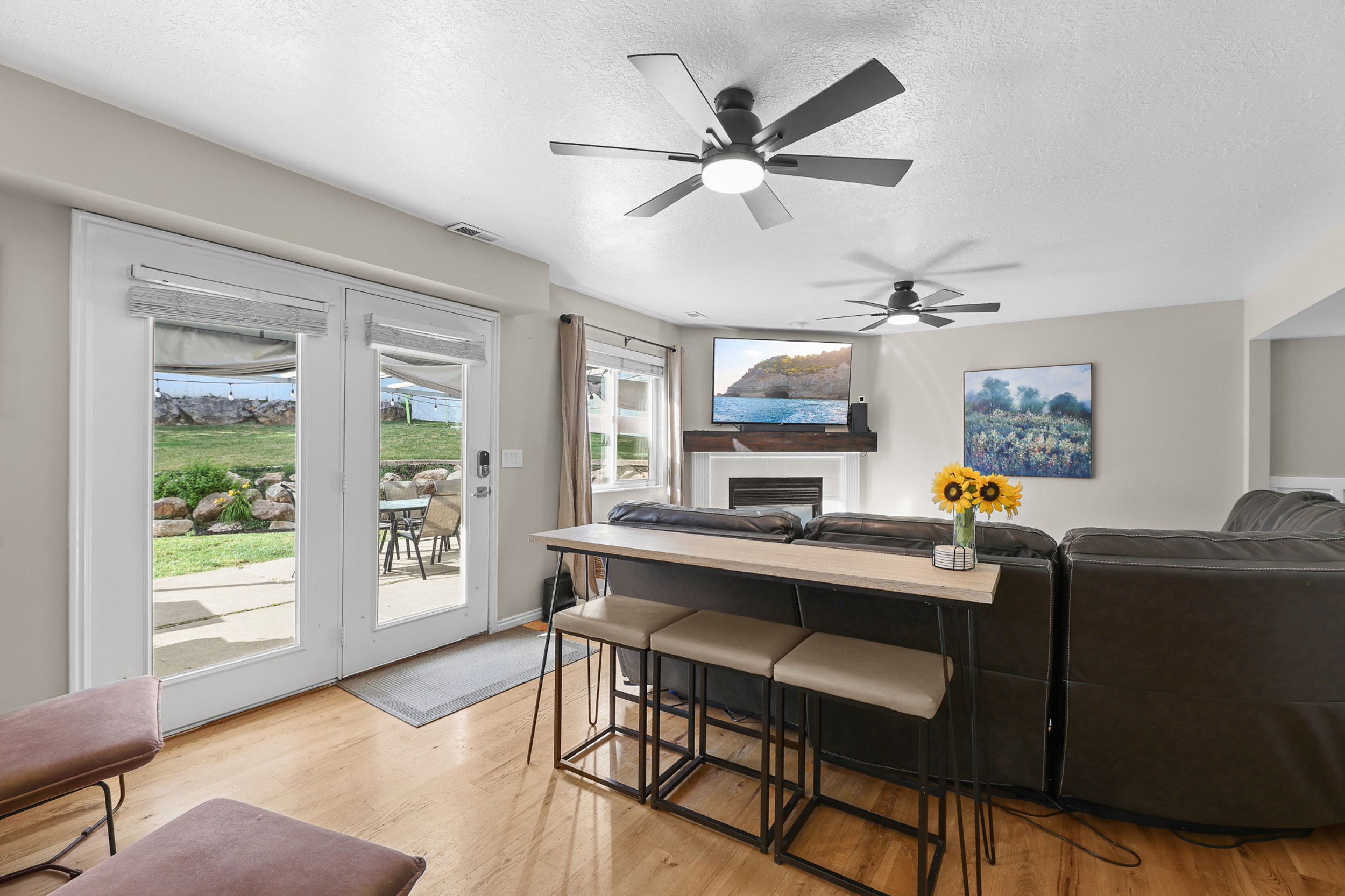 Living area featuring light wood-finish flooring, recessed lighting, and dual ceiling fans