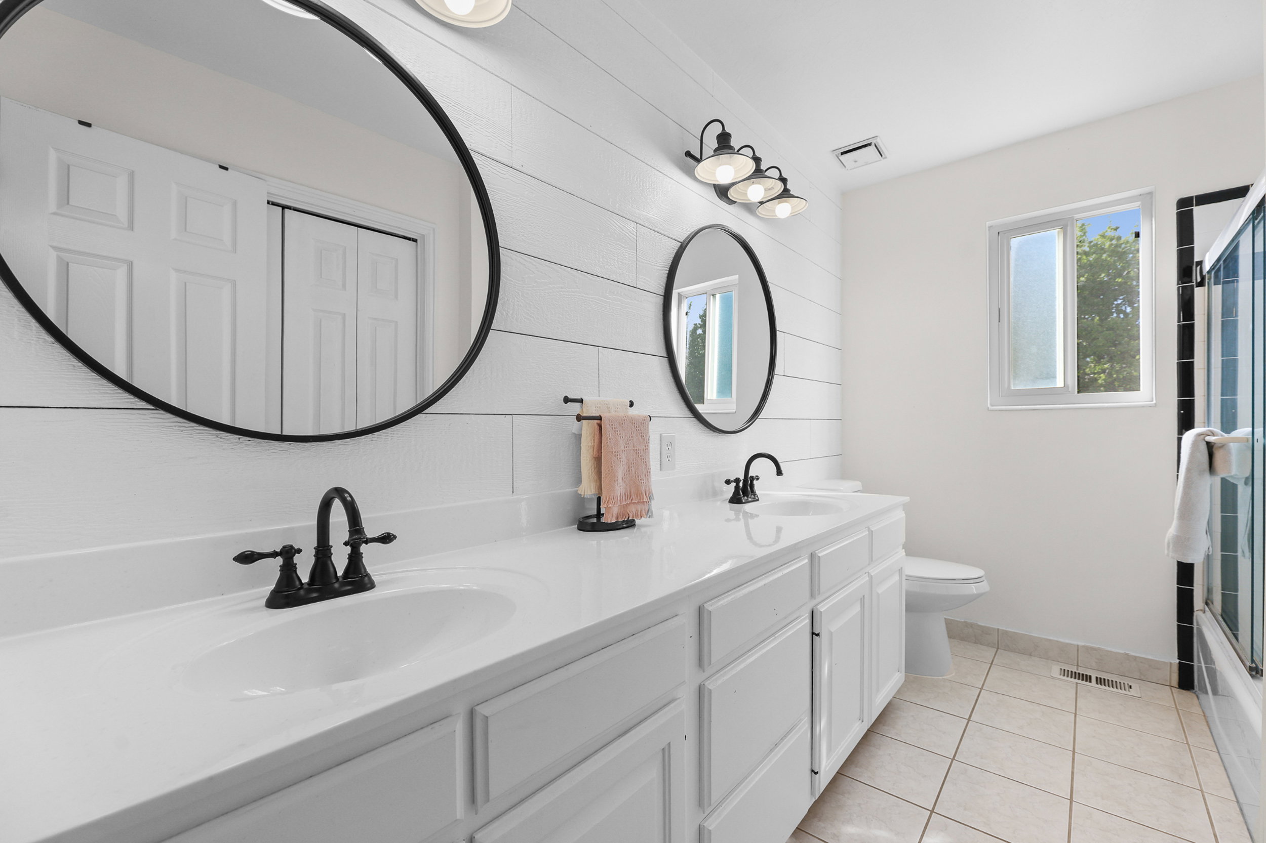 Dual vanity with white cabinetry and integrated sinks, complemented by matte black fixtures