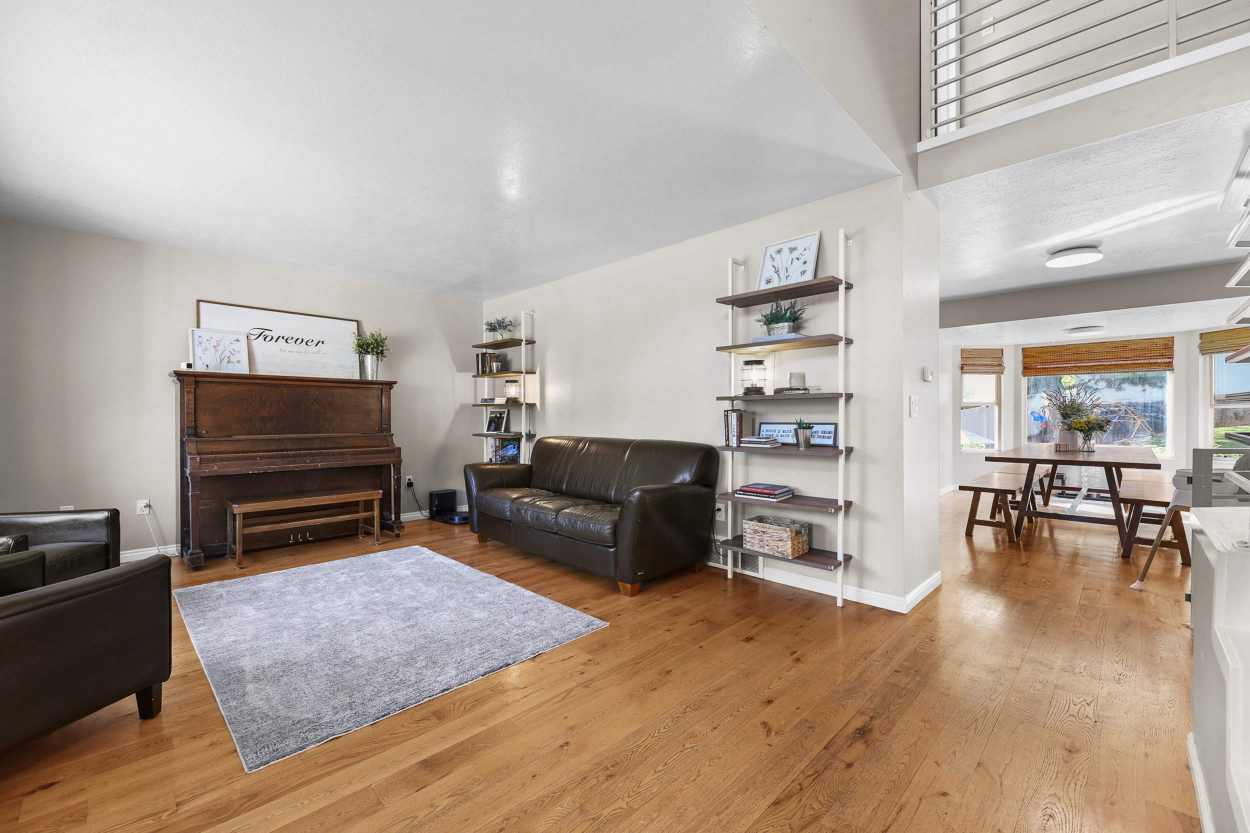 Spacious living area featuring wood-finish flooring, neutral wall tones, and built-in shelving