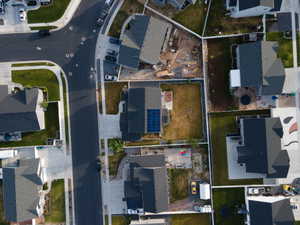 Overhead perspective showcasing a residential property with a dark shingle roof and solar panel array