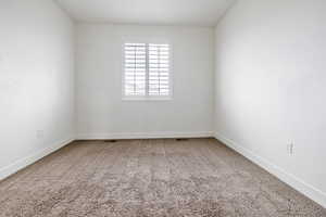 Bright room featuring light-colored walls and plush carpeting