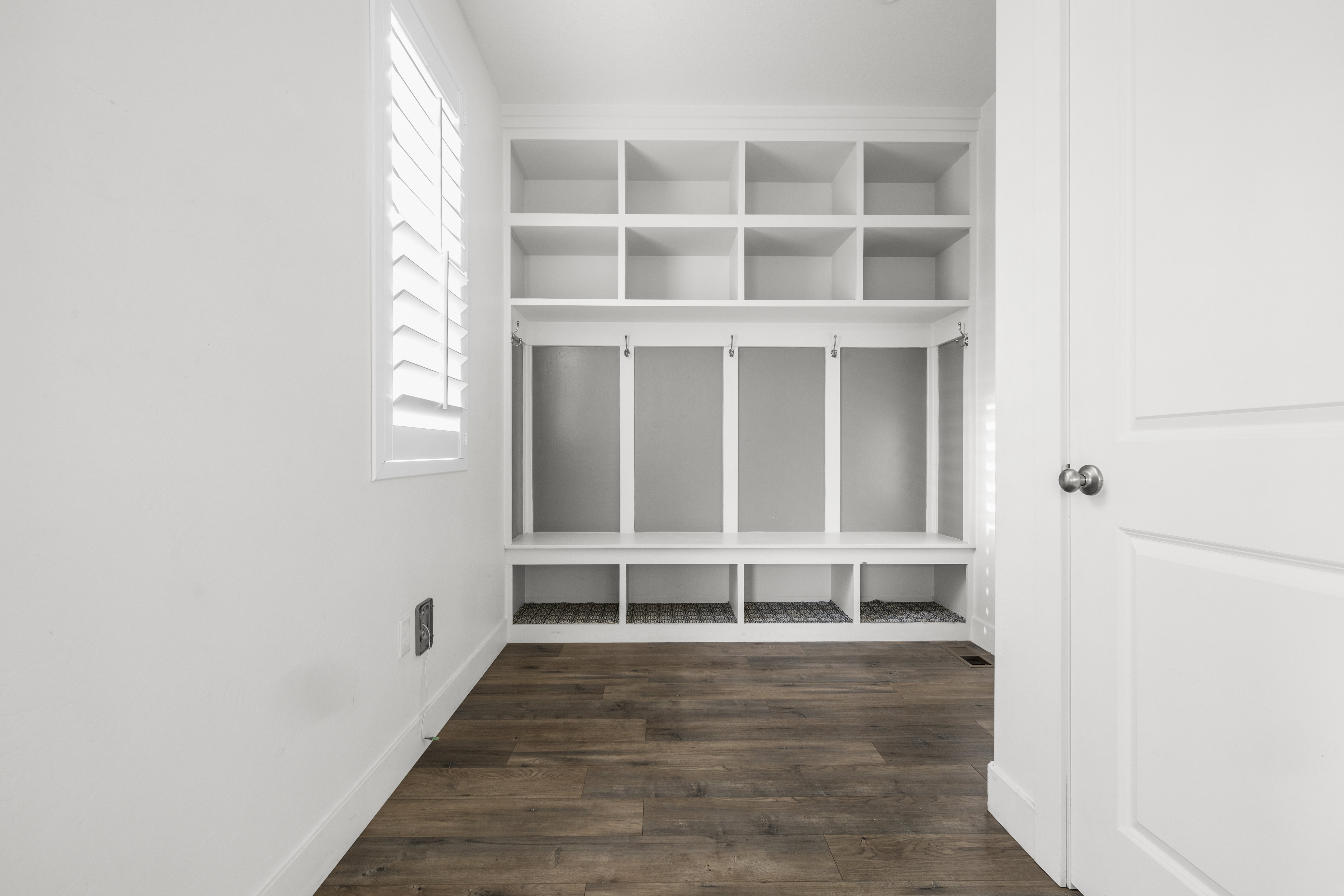 Built-in entryway storage system featuring cubbies, hooks, and bench seating
