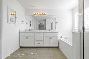 Primary bathroom. Dual vanity with white cabinetry, integrated sinks, and a light-toned countertop