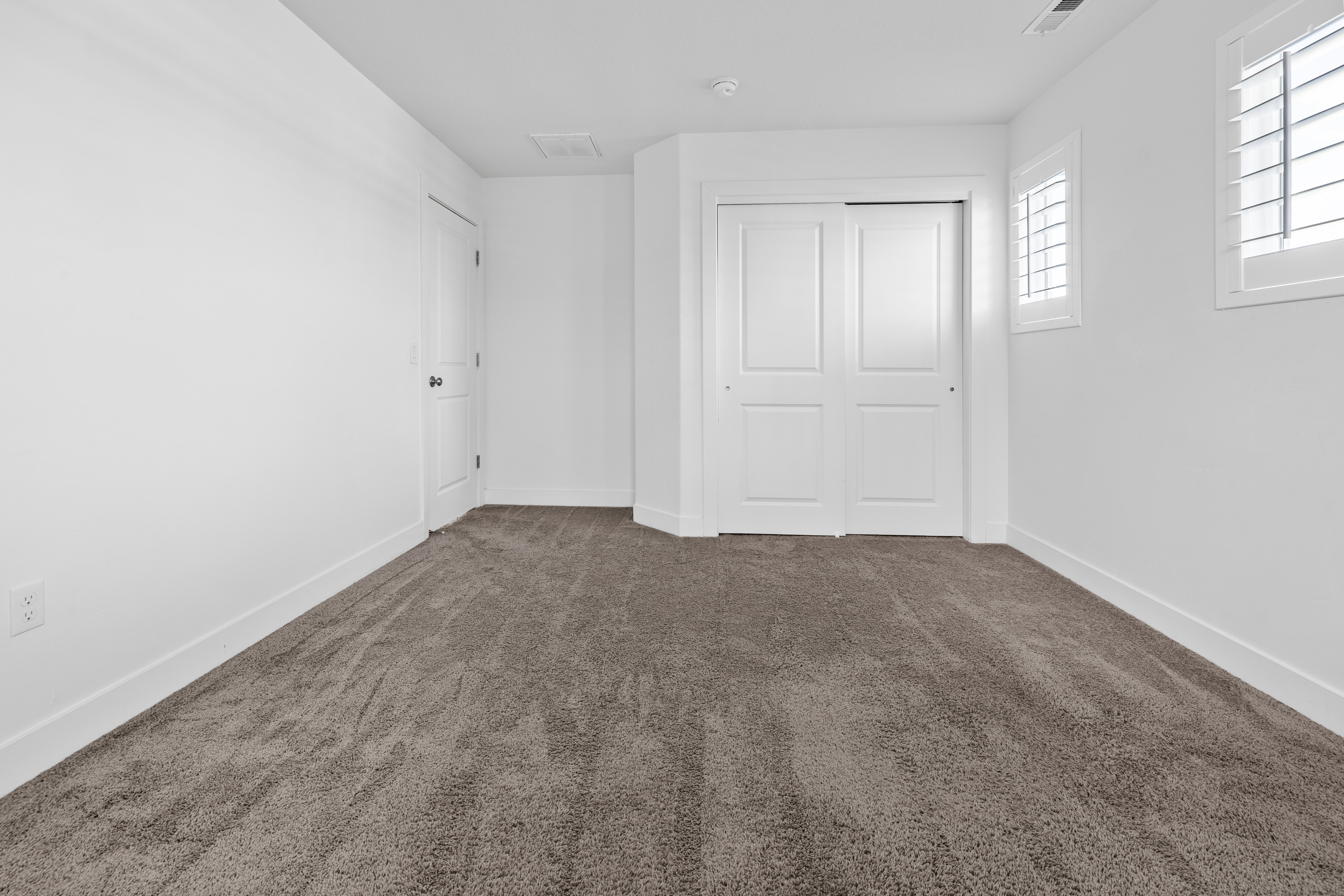 Bedroom 2 Plush carpeting and bright white walls create a neutral backdrop
