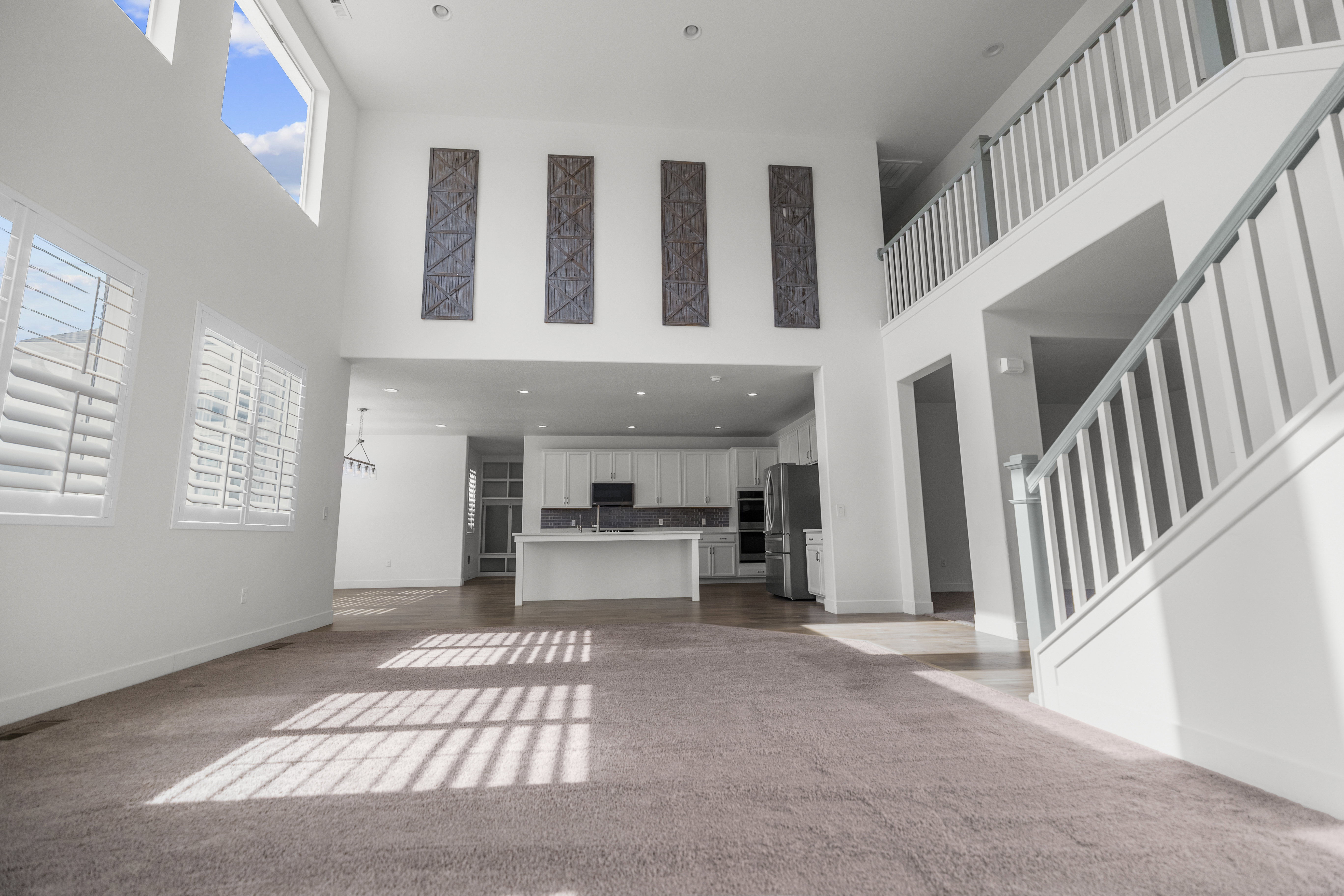 Two-story living area with high ceilings and upper windows