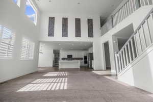 Two-story living area with high ceilings and upper windows