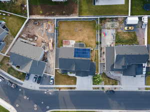 Overhead perspective of a residential property featuring a dark-toned shingled roof with solar panel installation
