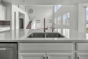 Kitchen island featuring a dual-basin stainless steel sink, two distinct faucets, and a light-toned countertop