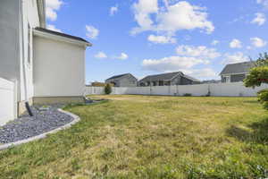 Expansive grassy back yard area featuring a perimeter fence