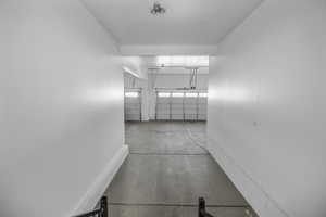 Double deep garage area featuring concrete flooring and three overhead doors