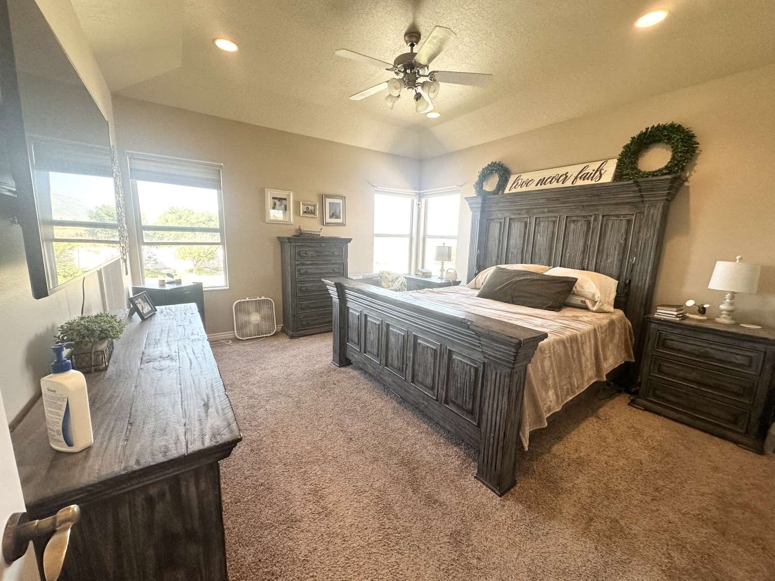 Carpeted bedroom with a vaulted ceiling and recessed lighting