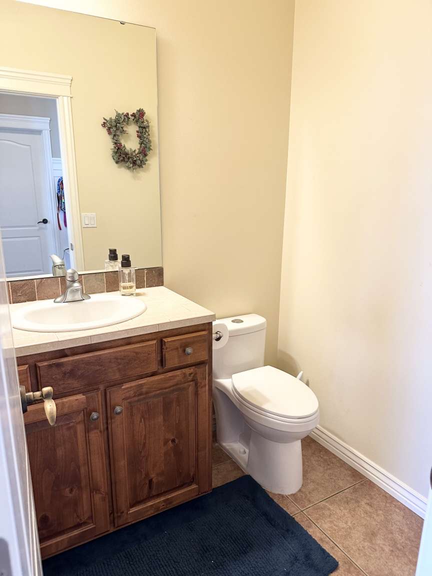 Bathroom vanity with a white countertop and integrated sink, set against neutral-toned walls