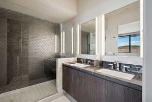 Full bath with double vanity and a shower stall